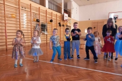 Dziewięcioro dzieci stoi w półkolu. W tle widać drabinki drewniane.