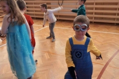 pięcioro dzieci stoi na sali gimnastycznej.  W tle widać duże okna.