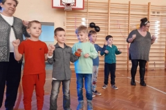 Pięciu chłopców stoi w szeregu. Obok nich stoją dwie panie.