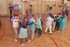 Grupa dzieci trzyma się za ramiona tworząc pociąg.