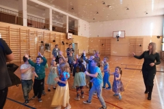 Duża grupa dzieci w sali gimnastycznej. W tle widać drewniane drabinki.