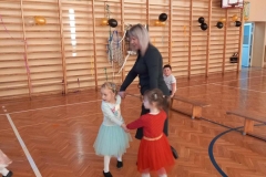 Dwie dziewczynki i pani trzymają się za ręce tworząc koło.