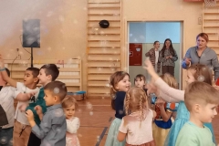 Grupa dzieci stoi w sali gimnastycznej