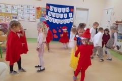 Dzieci przebrane za postacie bajkowe tańczą w parach w rytm muzyki.