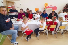 Babcie I dziadziowie siedzą wokół stołu.