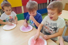 Dwóch chłopców I dziewczynka pocierała sól kolorową kredą.