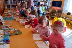 Dzieci zgromadzone wokół stołu, kolorują labirynt.