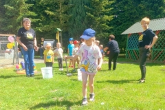 Dzieci ustawione w dwóch rzędach, przenoszą wodę w nalewce, tak by jej nie wylać.