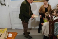 Dzieci wręczają upominek łowczemu.