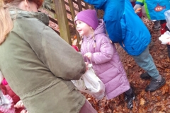 Dzieci wrzucają do paśnika smakołyki dla zwierząt.