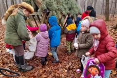 Dzieci wrzucają do paśnika smakołyki dla zwierząt.