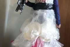 Dziewczynka stoi w stroju wykonanym z folii babelkowej.