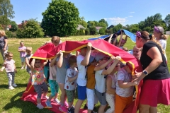 Grupa dzieci w kolorowych strojach stoi w rzędzie.