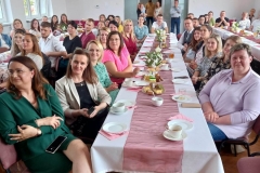 Zdjecie wykonane gruie rodziców siedzących pry nakrytym stole.