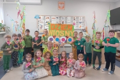 Cześć dzieci siedzi na podłodze,  trzymając w rękach kolorowe kwiaty. 11 chłopców stoi za nimi. Ubrani są w zielone koszulki. Wysłano Wysłano Duża grupa dzieci wraz z wychowawczynią siedzi na kolorowej chuście animacyjnej. Wysłano "Droga do szczęścia " - to tytuł przedstawienia w wykonaniu aktorów teatru lalek "Kukiełka " z Ptaszkowej, który obejrzały dzieci z naszego przedszkola oraz przedszkolaki z Jadownik Mokrych. Dzieci z ciekawością śledziły losy bohaterów, podziwiały piękne lalki. Przedstawienie pozostawiło wiele niezapomnianych wrażeń. Wysłano Wysłano Zdjęcie przedstawia cztery lalki siedzące na scenie. Obok nich jest niewielki drewniany domek. Wysłano Wysłano Grupa dzieci w kolorowych strojach siedzi na podłodze. Pozostałe siedzą na krzesełkach. Za nimi widać okna. Wysłano Wysłano Grupa dzieci siedzi na podłodze, pozostałe siedzą na krzesłach.