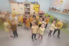 Dzieci stoją w parach trzymając się za ręce. W tle widać szafki