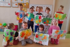 Kilkoro dzieci stoi w rzędzie, przed nimi siedzi czworo dzieci, każde z nich trzyma w ręku bużki  emocje.