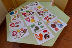 Na stoliku leżą kolorowe, pomalowane prace dzieci.