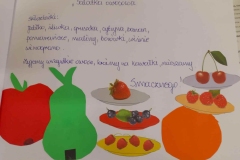 Na kartce napisany przepsi na sałatkę owoccową, pod przepisem wyklejone kolorowe owoce.