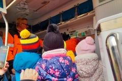 Dzieci są w karetce. Ratownik opowiada im co jest w środku