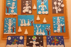 Na gazetce wiszą pracę wykonane z płatków kosmetycznych na niebieskich I czarnych kartkach.