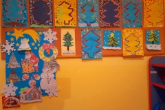 Kolorowe, świąteczne prace dzieci na tablicy.