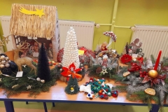 Na stole leżą stroiki świąteczne wykonane z różnych materiałów.