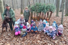 Dzieci w kolorowych strojach stoją wokół paśnika.