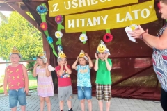 Pięcioro dzieci w kolorowych strojach stoją w szeregu.