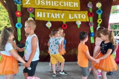 Dzieci stoją w paach, zwrócone do siebie twarzami, trzymają się za ręce.