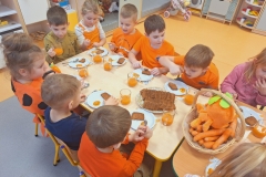 Dzieci przy stoliku jedzą ciasto marchewkowe