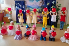 Dzieci ustawione w dwóch rzędach w rękach trzymają balony.