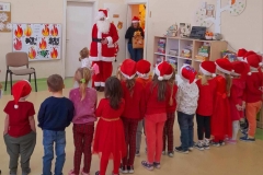 Grupa dzieci stoi tyłem, w drzwiach widać św. Mikołaja