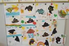 Do tablicy przypięte są prace plastyczne wykonane przez dzieci i rodziców. Są to czarne plamy - symbole złości zamienione przy pomocy kolorowych papierów, bibuły i kredek w coś innego, radosnego. Wyżej nad nimi znajduje się tablica z literami.