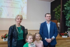 Dwie dziewczynki stoją obok siebie.  Po bokach pan i pani.