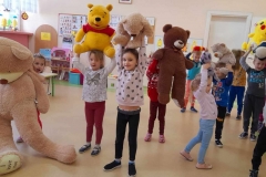 Grupa dzieci bawi się do wiersza, podnosi Misie do góry.