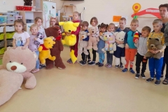 Dzieci stoją, każde z nich trzyma w ręku pluszowego misia.