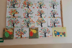 Na zdjęciu drzewa na których wiszą kolorowe, jesienne liście.