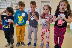 Piecioro dzieci stoi obok siebie, w ręku trzymają medale za zajęcie drugiego miejsca w konkursie układania puzzli.