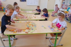 Dzieci siedzą po obu stronach stolika, układają puzzle. Wiesława Wiesława Troje dzieci układa puzzle przy stolikach. Wiesława Wiesława Czworo dzieci stoi, w ręku trzymają medale za zajęcie pierwszego miejsca w konkursie układania puzzli. Wiesława Wiesława Piecioro dzieci stoi obok siebie, w ręku trzymają medale za zajęcie drugiego miejsca w konkursie układania puzzli. Wiesława Wiesława Dwóch chłopców stoi obok siebie  w ręku trzymają medale za zajęcie trzeciego miejsca w konkursie układania puzzli. Wiesława Wiesława Patoń Wiesława Wiesława Patoń Konkurs układania puzzli u Misiów. W piątek wśród Misiów odbył się konkurs układania puzzli. Jest to grupa mieszana dlatego, stopień trudności był zróżnicowany. Dzieci młodsze układały łatwiejsze puzzle, starsze trudniejsze z większą ilością elementów. Podczas konkursu wyrabiano u dzieci umiejętność logicznego myślenia i koncentracji, słuchania poleceń nauczyciela oraz wdrażano je do zgodnej rywalizacji. W konkursie wzięło udział 11 dzieci. Czas minął nam miło i radośnie.