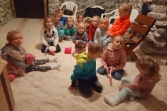 Dzieci bawią się w soli, dwoje z nich siedzi na ławeczce, w tle widać skrzynie.