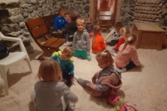 Dzieci bawią się w soli, dwoje z nich siedzi na ławeczce, w tle widać skrzynie.