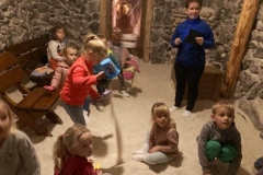 Dzieci bawią się w grocie solnej solą, dziewczynka wysypuje sół z wiaderka.