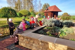 Grupa dzieci wspina się na zieloną górkę.