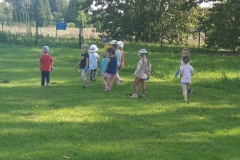 Grupa dzieci rozgląda się w poszukiwaniu śmieci.