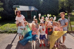 Na zdjęciu grupa dzieci z dwoma paniami, każde dziecko ma  na ręce  foliowe rękawiczki. Trojka dzieci trzyma kolorowe worki.