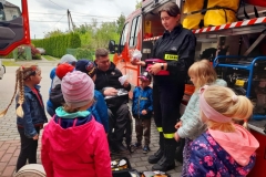 Druhną Julią pokazuje dzieciom zawartość apteczki strażackiej.