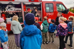 Druhną Marcin opowiada dzieciom co znajduje się w wozie strażackim.