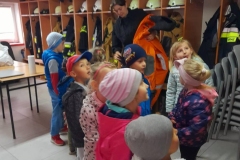 Druhną Julią pokazuje dzieciom co znajduje się w szatni strażaków.