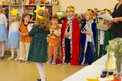 Grupa dzieci przebrana za postacie z jaselek, na środku wózek dla lalek.